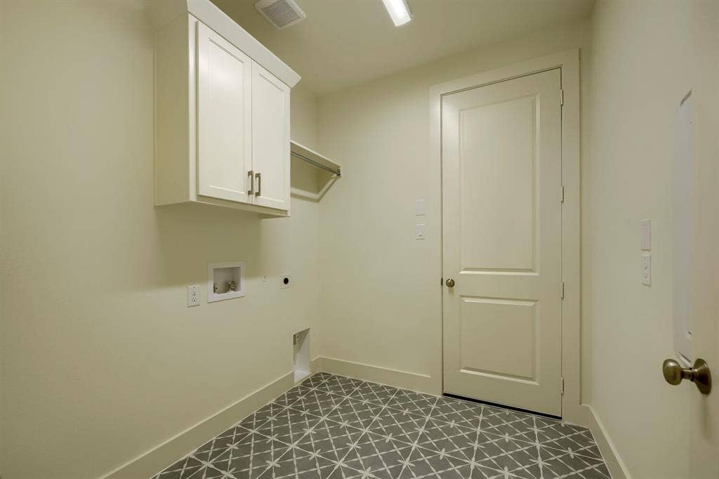 690 Red Cedar Road, Haslet, TX 76052 Laundry area featuring patterned floor tile, overhead cabinetry, and a clothes hanging rod