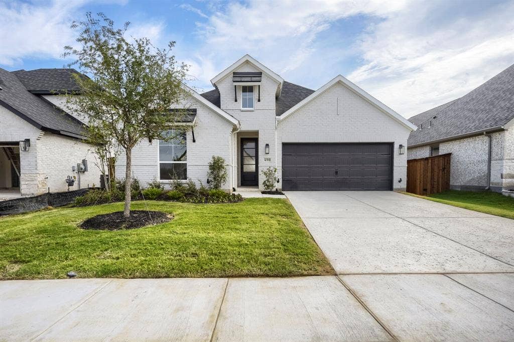 690 Red Cedar Road, Haslet, TX 76052 Modern farmhouse-style exterior featuring white brick, dark gray garage door, and a black front door