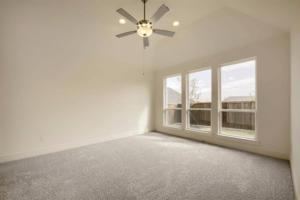 690 Red Cedar Road, Haslet, TX 76052 Vaulted ceiling with a ceiling fan, recessed lighting, three large windows, and carpet flooring
