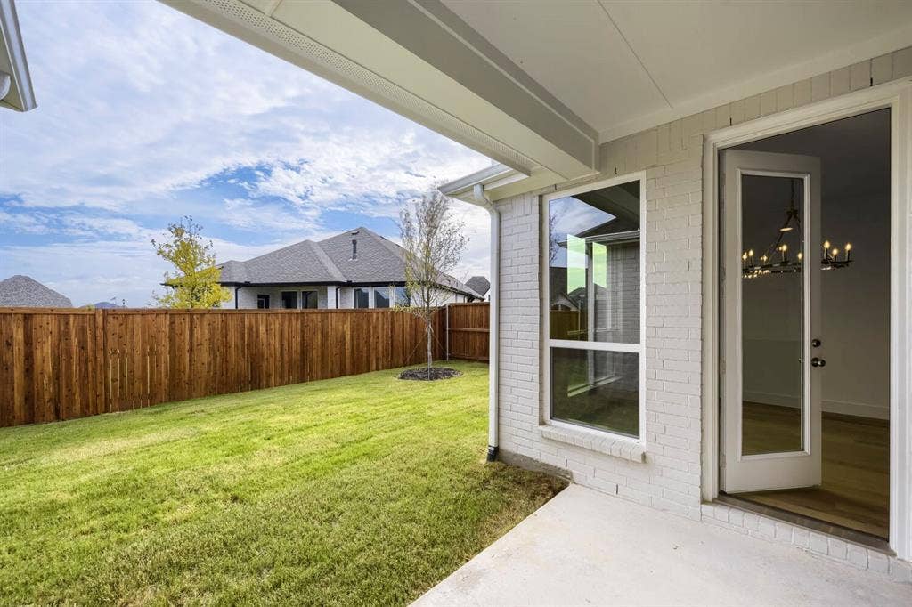 690 Red Cedar Road, Haslet, TX 76052 Expansive backyard featuring a manicured lawn, wood privacy fence, and concrete patio