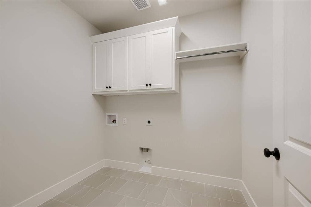 1281 White Pine Drive, Haslet, TX 76052 Laundry area featuring white shaker-style cabinetry, a built-in hanging rod, and tile flooring