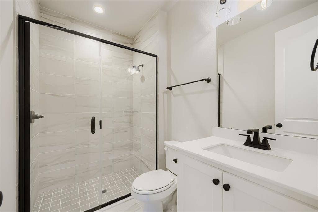 1281 White Pine Drive, Haslet, TX 76052 Glass-enclosed shower with matte black framing, white tile walls, and a tiled shower pan