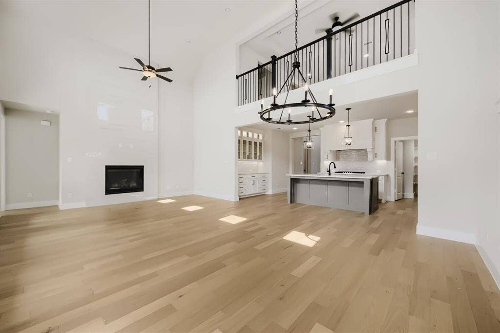 1281 White Pine Drive, Haslet, TX 76052 Vaulted ceilings, wood-finish flooring, and a contemporary fireplace with a sleek surround