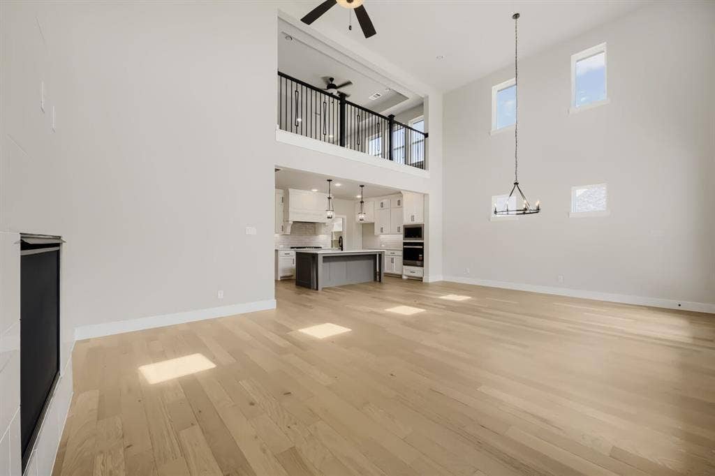 1281 White Pine Drive, Haslet, TX 76052 Two-story living area with high ceilings, wood-finish flooring, and a fireplace