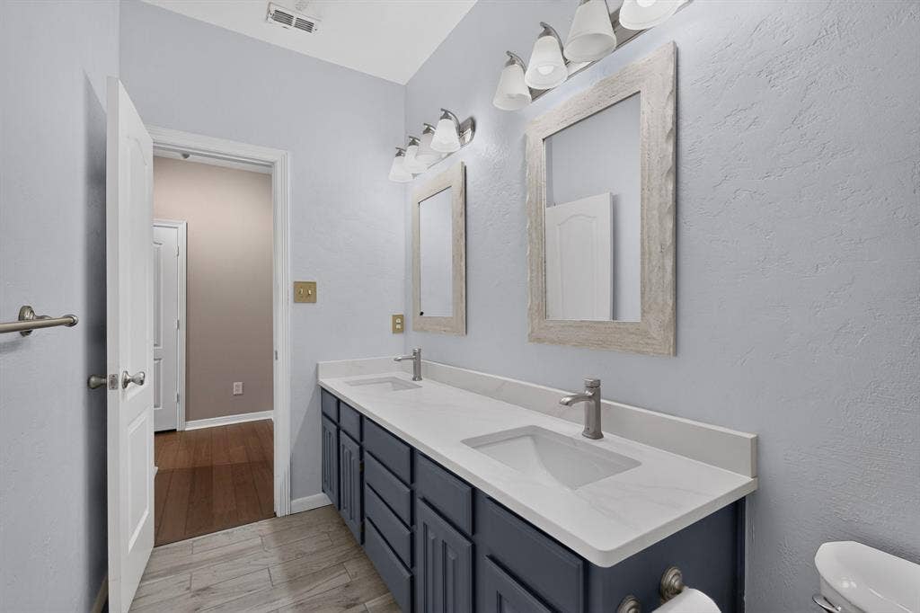 713 Mockingbird Court, Crowley, TX 76036 Dual vanity with integrated sinks, white countertops, and brushed nickel fixtures