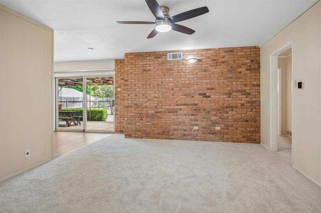 902 N Lindale Lane, Richardson, TX 75080 The spacious den is anchored with a warm and aesthetically pleasing floor to ceiling brick wall.