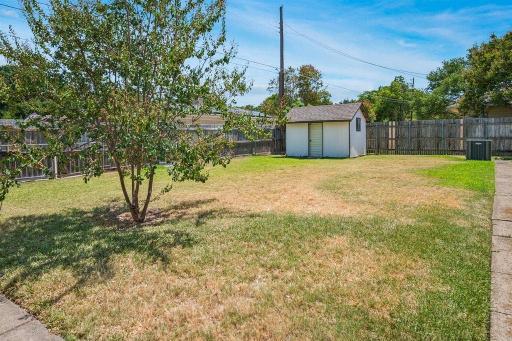 902 N Lindale Lane, Richardson, TX 75080 Open green space for the kids to play along with a storage shed for added utility.