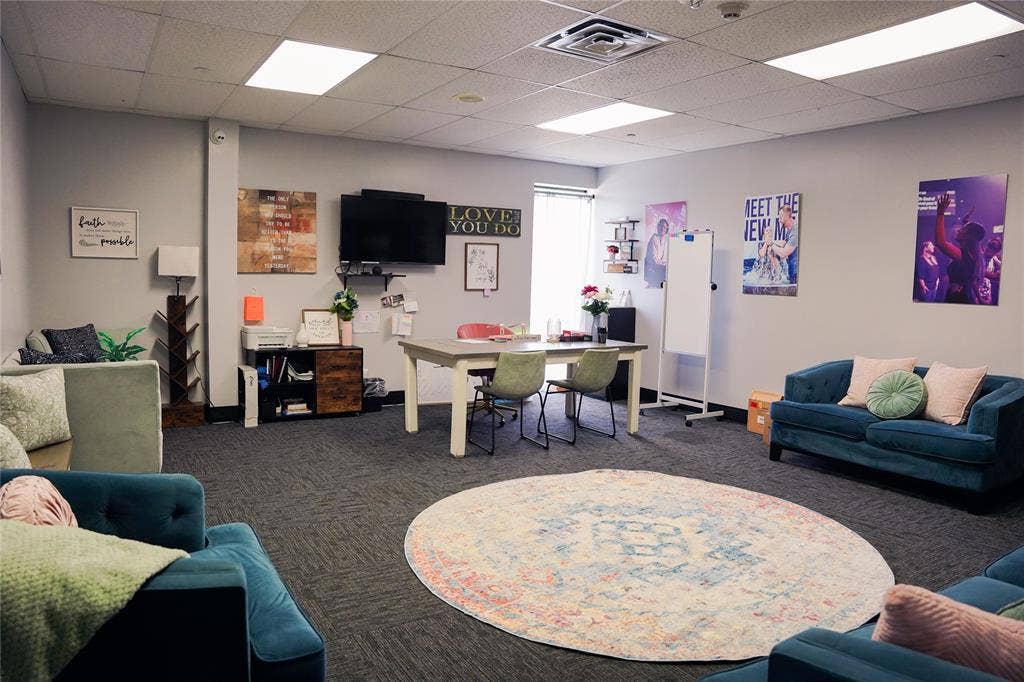 2705 Virginia Parkway, McKinney, TX 75071 Modern collaborative workspace featuring open-concept layout with multiple seating zones, including teal upholstered lounge furniture and round area rug