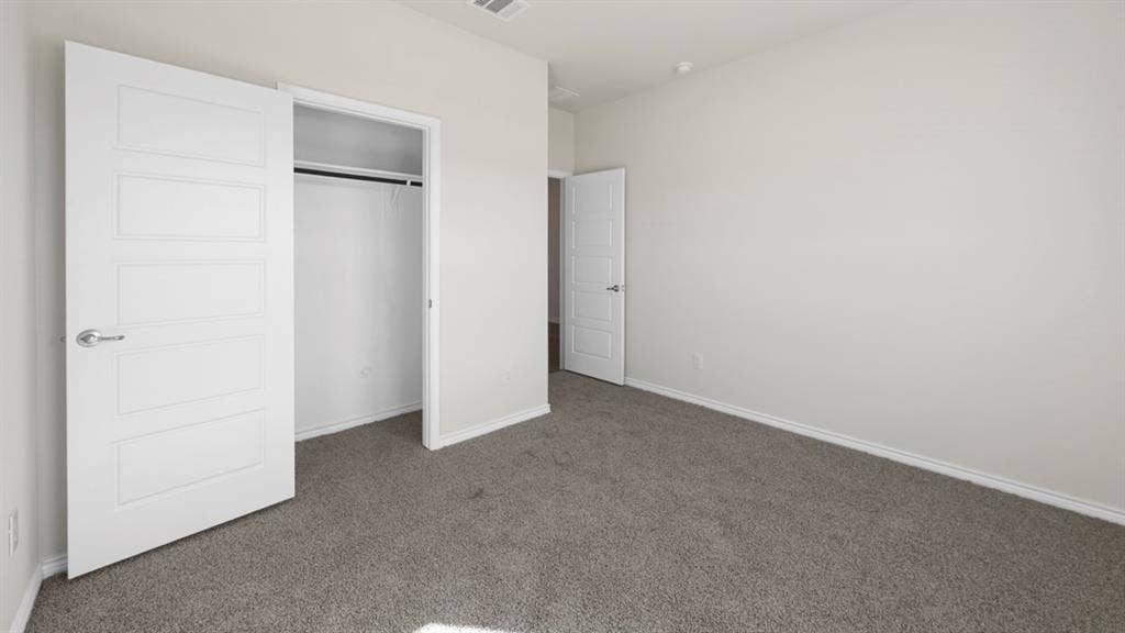 8425 Everly Drive, Garland, TX 75043 Carpeted room with white paneled doors, white baseboards, and neutral wall tones