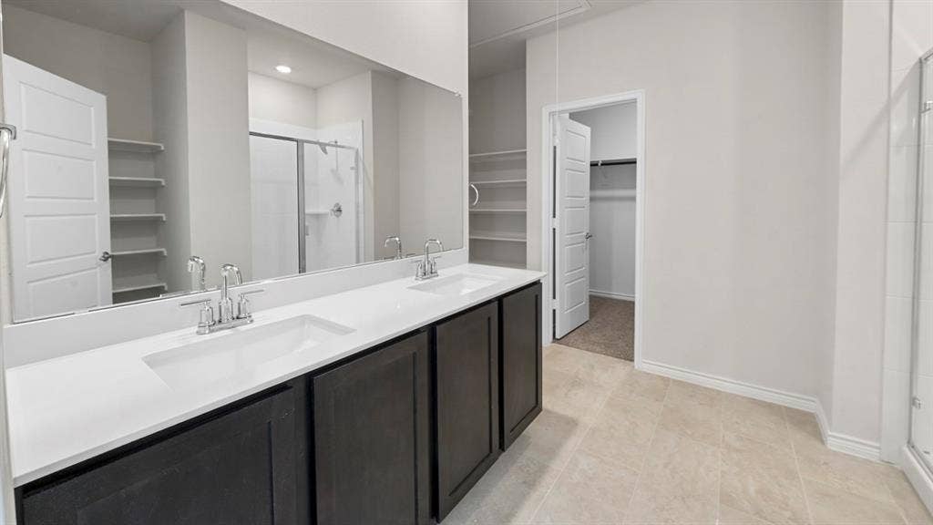 8425 Everly Drive, Garland, TX 75043 Bathroom featuring a dual vanity with dark wood-finish cabinetry, white countertop, and integrated sinks
