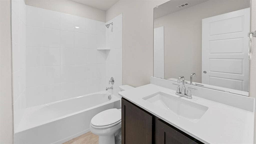8425 Everly Drive, Garland, TX 75043 Contemporary bathroom featuring a dark wood-finish vanity with a white countertop and integrated sink