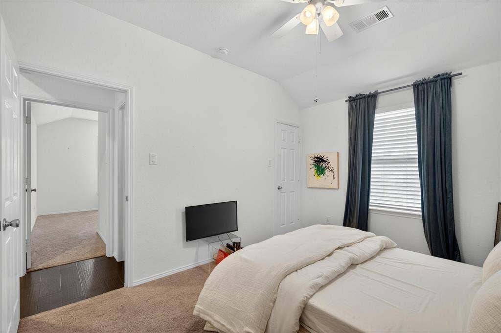 Carpeted room featuring a ceiling fan, window with blinds, and white paneled doors