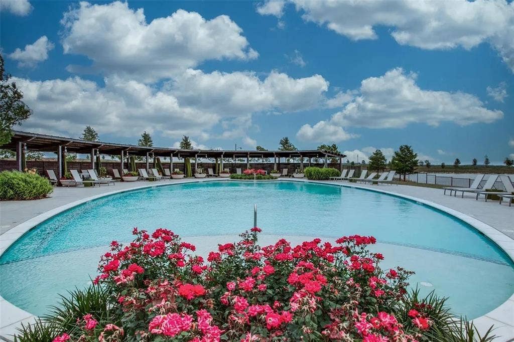 Expansive outdoor pool with a curved design, surrounded by a paved deck