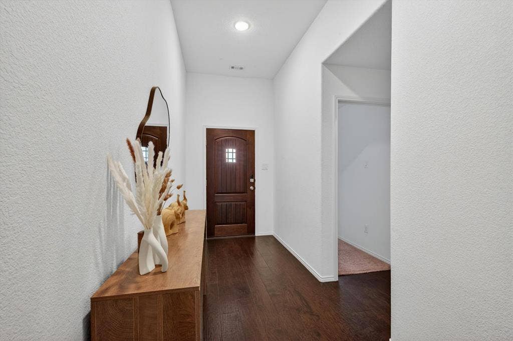Entryway featuring a dark wood-finish door with grid-patterned glass inserts and dark wood-finish flooring