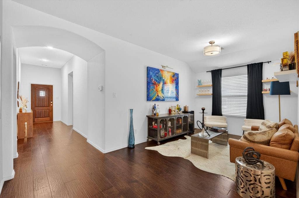 Living area featuring dark wood-finish flooring, white walls, and a ceiling-mounted light fixture
