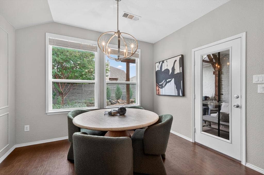 Dining area featuring wood-finish flooring and a contemporary chandelier