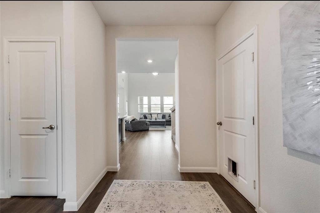 902 Western Way, Princeton, TX 75407 Elegant foyer featuring clean-lined white panel doors, warm neutral walls, and dark wood-finish flooring