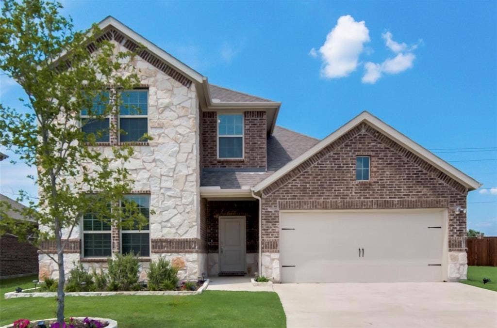 902 Western Way, Princeton, TX 75407 Two-story residence featuring a combination stone and brick facade, a two-car garage, and a concrete driveway
