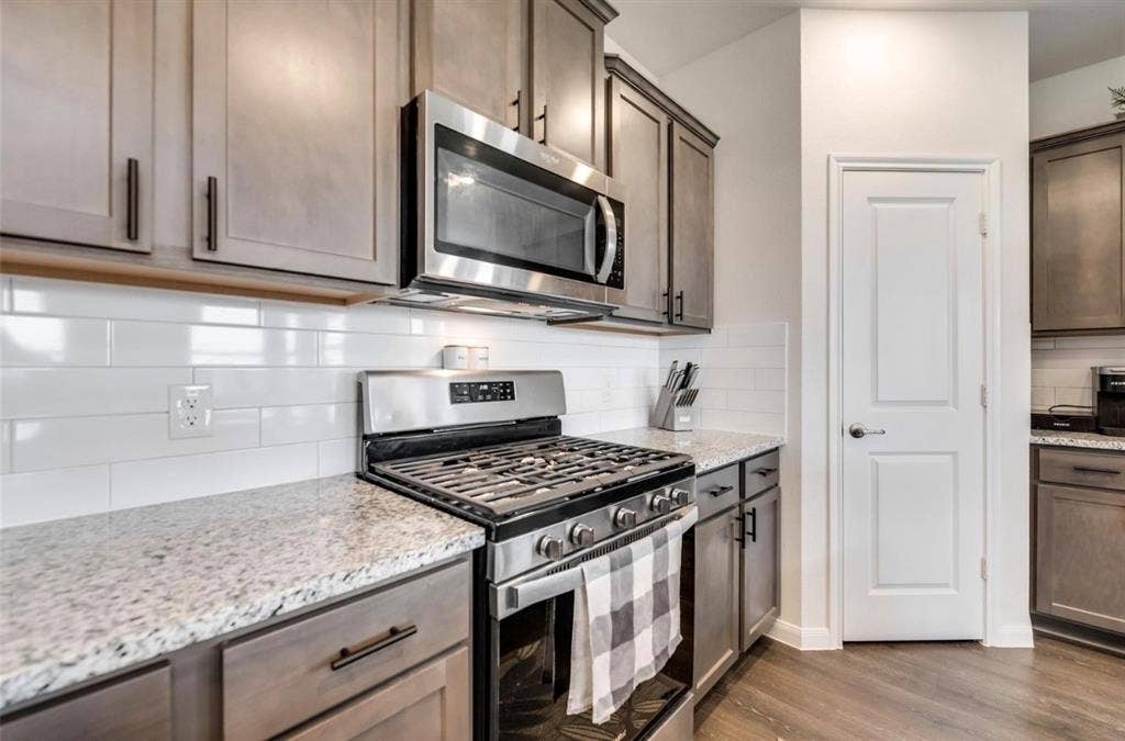 902 Western Way, Princeton, TX 75407 Kitchen featuring stainless steel appliances, light wood-finish cabinetry, granite-style countertops, and a white subway tile backsplash