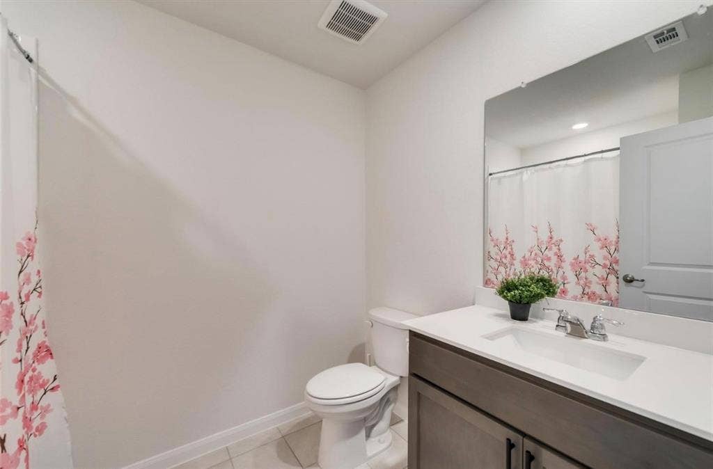 902 Western Way, Princeton, TX 75407 Bathroom featuring a gray vanity with a white countertop and integrated sink, a large wall-mounted mirror, and tile flooring