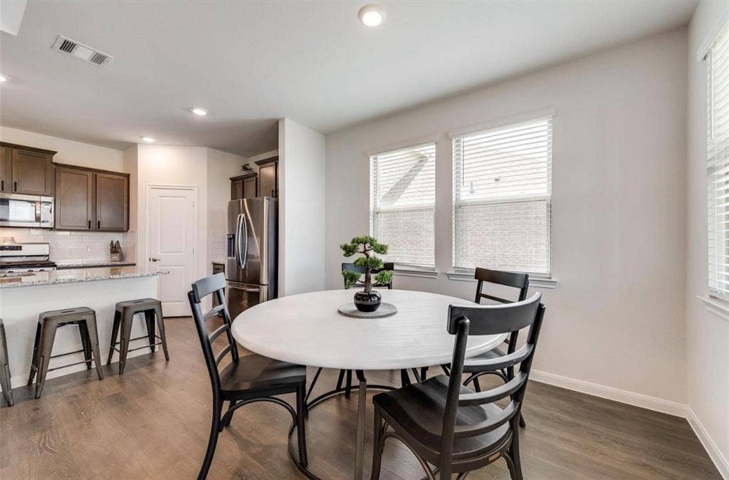 902 Western Way, Princeton, TX 75407 Kitchen and dining area featuring wood-finish flooring, recessed lighting, and multiple windows with blinds