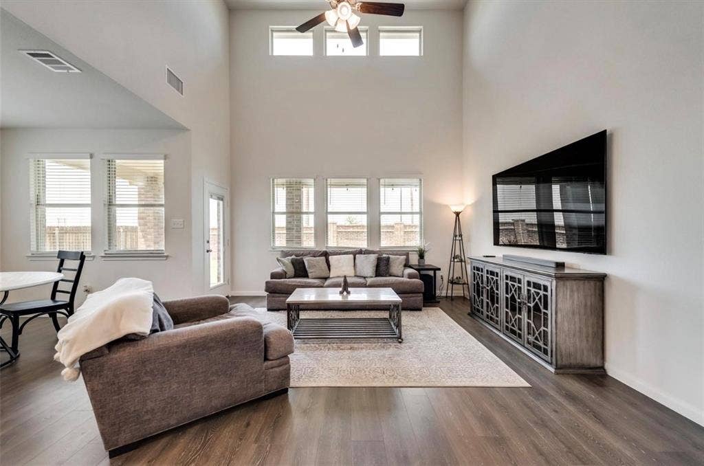 902 Western Way, Princeton, TX 75407 Living area with vaulted ceilings, wood-finish flooring, and multiple windows