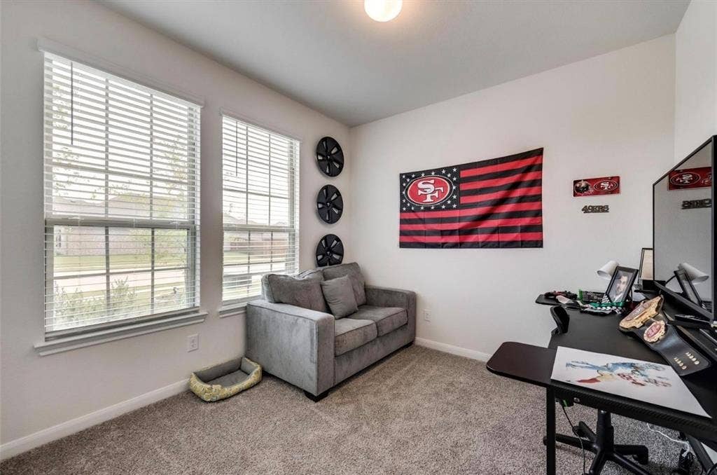 902 Western Way, Princeton, TX 75407 Versatile interior space featuring two windows with horizontal blinds, carpeted flooring, and a ceiling-mounted light fixture