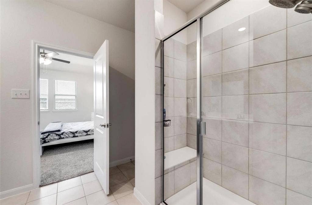 902 Western Way, Princeton, TX 75407 Spa-inspired primary bathroom featuring a frameless glass-enclosed shower with subway tile surround, polished chrome fixtures, and recessed ceiling lighting