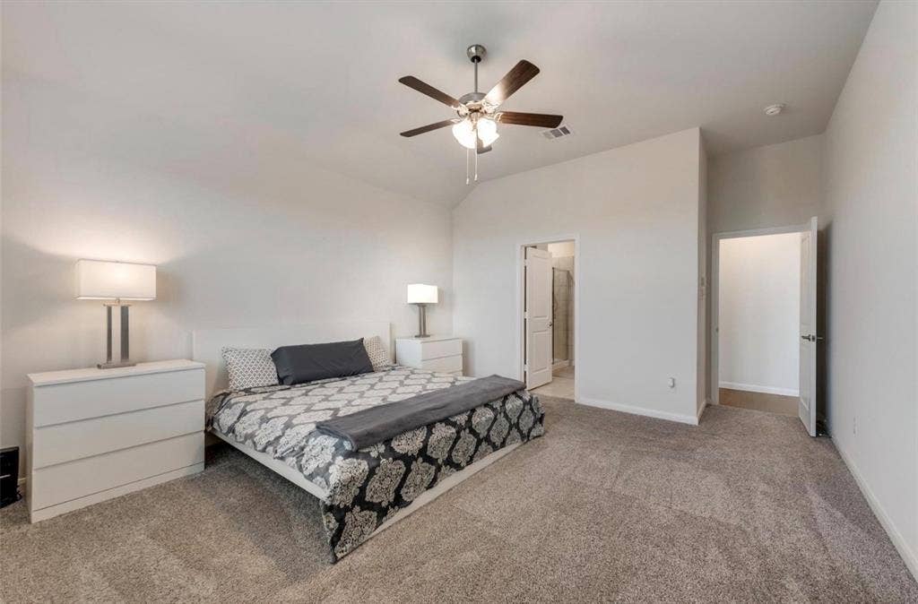 902 Western Way, Princeton, TX 75407 Spacious primary bedroom featuring neutral carpeting, abundant natural light from multiple windows, and a ceiling fan with integrated lighting