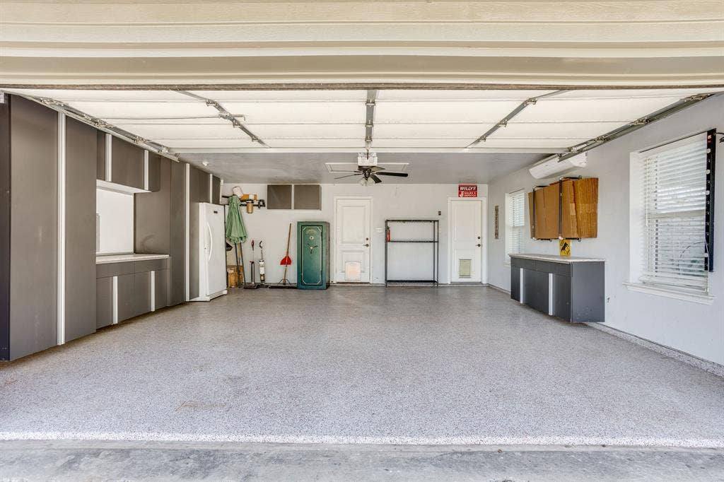 220 Royal Court, Weatherford, TX 76085 21x21 oversized garage with built in shelving, epoxy finished floor, mini-split with heat and air. There is also flat screen wiring below the mini-split and direct access to the patio and pool.