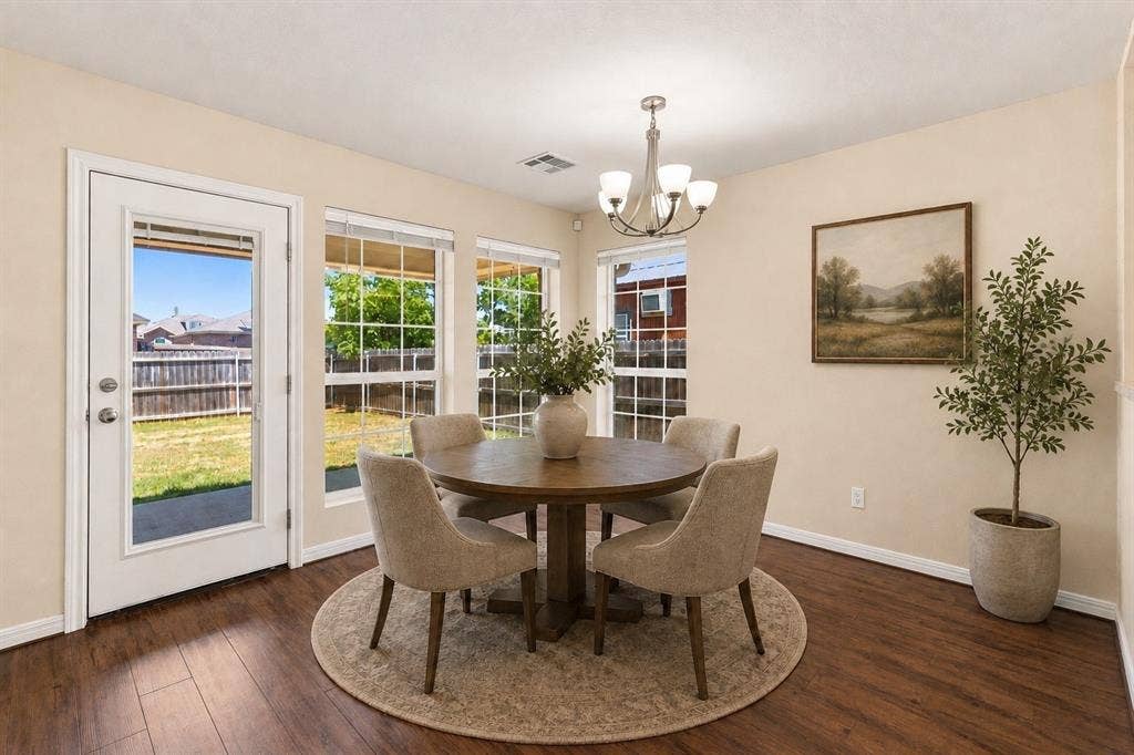 204 Raven Ridge Court, Lacy Lakeview, TX 76705 Virtual rendering. Elegant dining room featuring hardwood flooring, a round pedestal table, and upholstered chairs arranged on a neutral-toned area rug