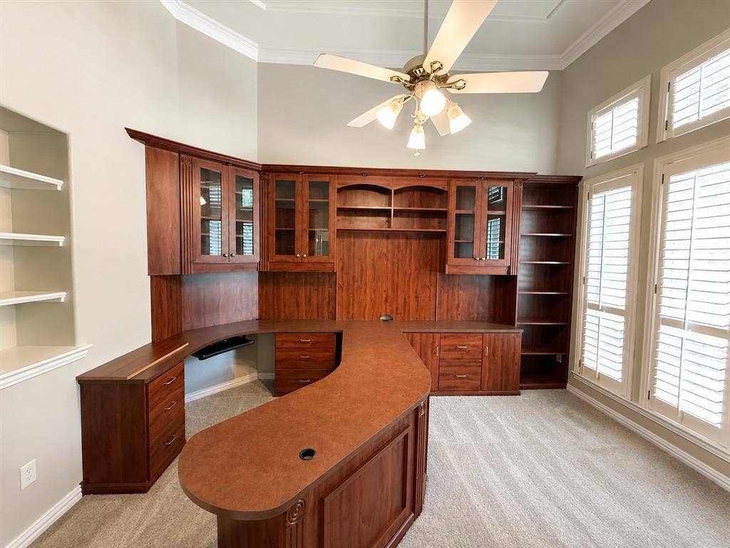 Built-in cherry wood cabinetry with glass-front uppers and a curved desktop