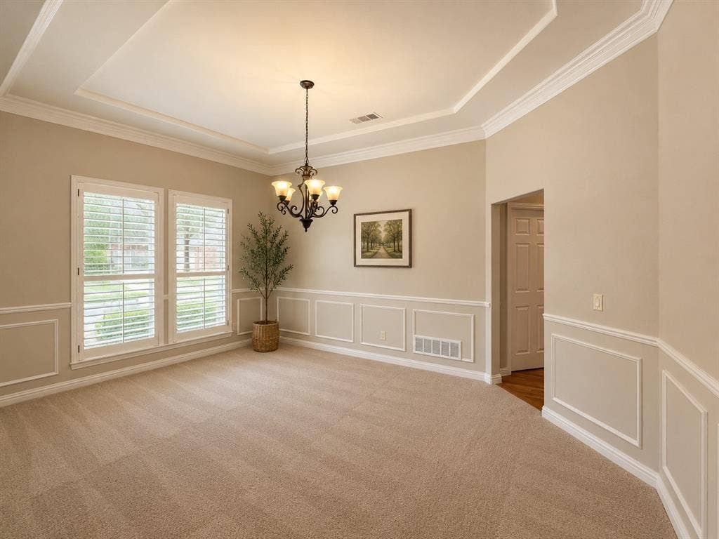 Spacious room with a tray ceiling and crown molding