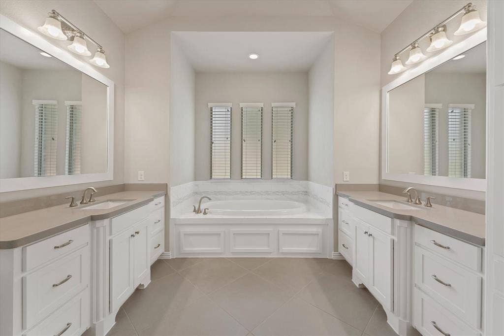 10846 Smoky Oak Trail, Argyle, TX 76226 The primary bedroom is located on the first floor and has a perfect split floorplan with the other bedroom in the mother in law wing. Both feature an ensute bath. The main primary bath is huge! It features a nice tile walk in shower, a large garden soaking tub, and separte vanities as well as a gigantic walk in closet.
