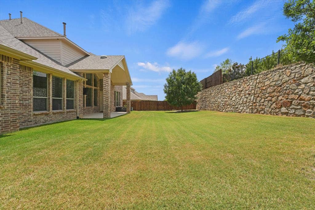 10846 Smoky Oak Trail, Argyle, TX 76226 This yard is huge as the home sits on over a quarter acer lot! There is room here for endless ideas like a great pool and more. The stone wall and stained fence are in great condition. The yard is well maintained. The backyard backs up to a greenbelt for extra quiet and privacy.