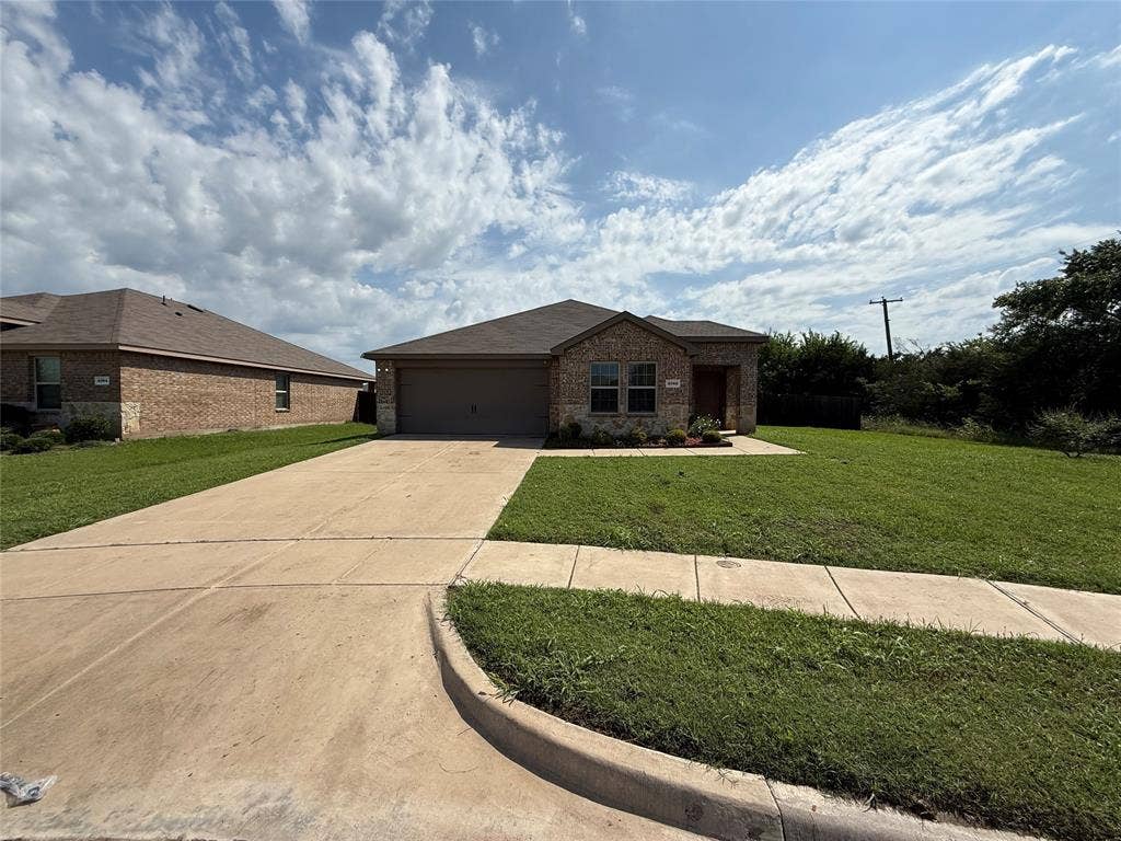 2702 Marotto Way, Seagoville, TX 75159 Brick facade residence with an attached garage, concrete driveway, and front lawn