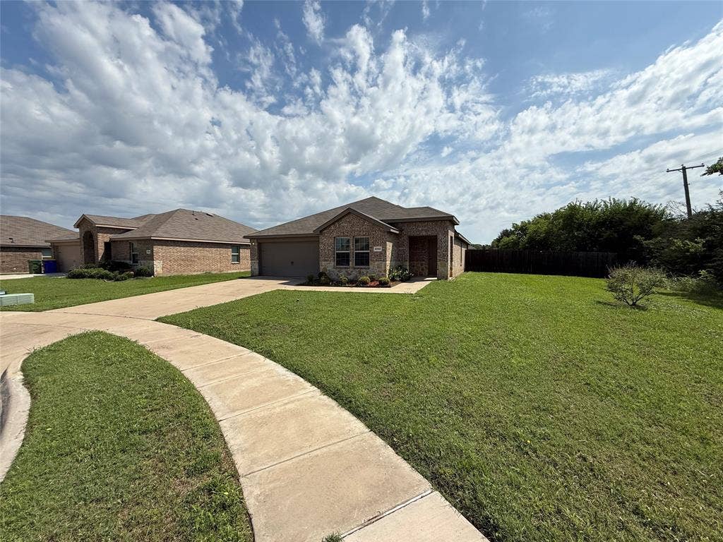 2702 Marotto Way, Seagoville, TX 75159 Single-story home featuring a brick facade with stone accents, an attached garage, a concrete driveway, and a concrete pathway