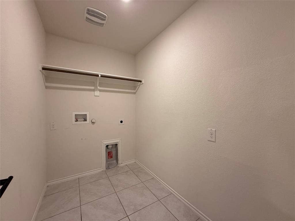 2702 Marotto Way, Seagoville, TX 75159 Dedicated laundry area featuring ceramic tile flooring, neutral wall tones, a built-in shelf with hanging rod, and essential appliance hookups