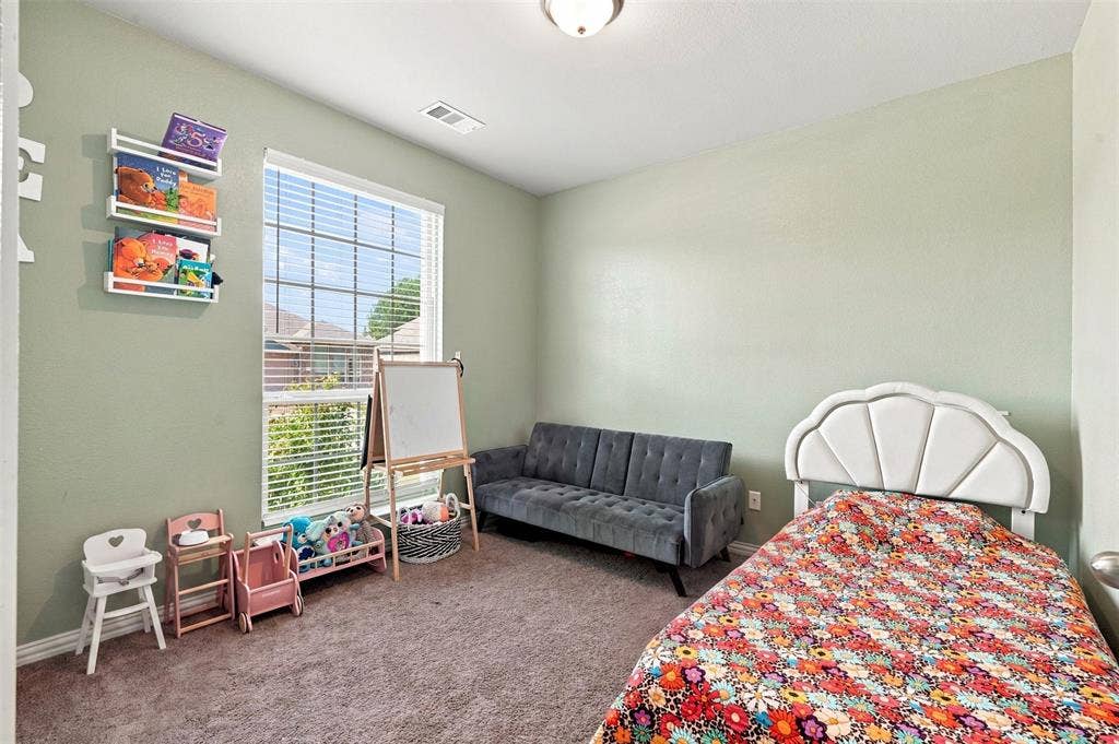 Carpeted room with a large window featuring horizontal blinds