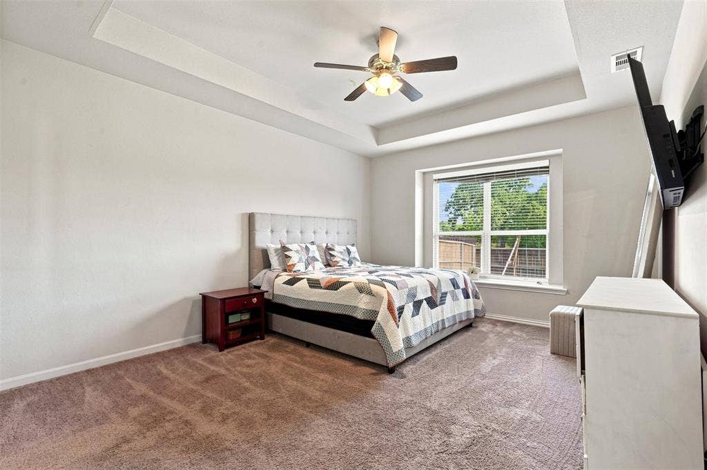Bedroom featuring a tray ceiling, recessed lighting, and a ceiling fan