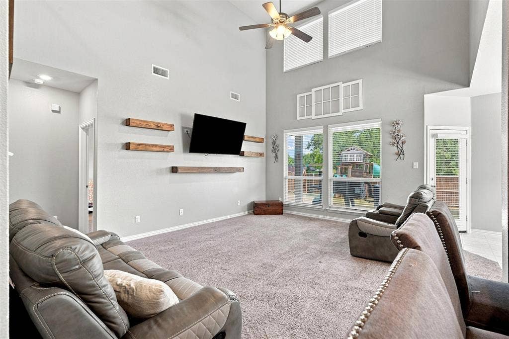 Spacious interior featuring a vaulted ceiling and a ceiling fan