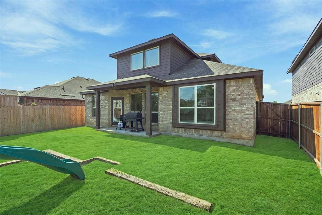Expansive green lawn with a covered patio area