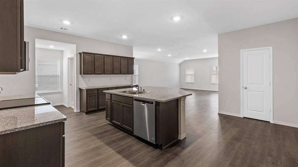 401 Banner Avenue, Royse City, TX 75189 Spacious kitchen featuring dark wood cabinetry, granite countertops, a central island with a stainless steel dishwasher, and recessed lighting