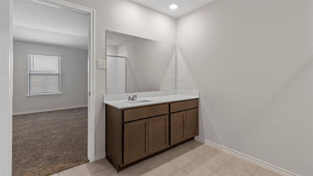 401 Banner Avenue, Royse City, TX 75189 Bathroom vanity featuring a single sink, light-colored countertop, and dark wood-finish cabinetry