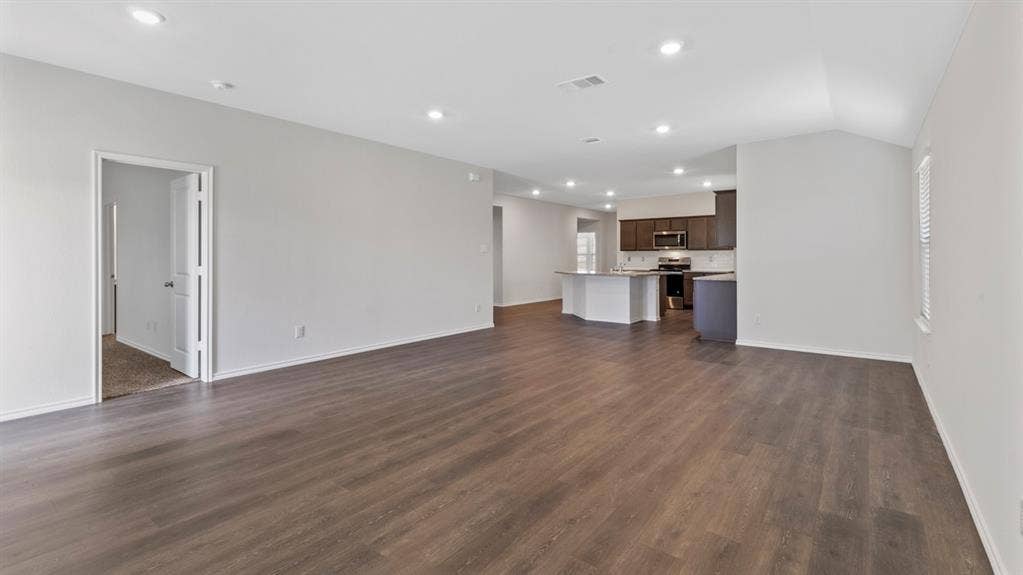 401 Banner Avenue, Royse City, TX 75189 Spacious open-concept living area featuring wood-finish flooring, recessed lighting, and light neutral wall tones