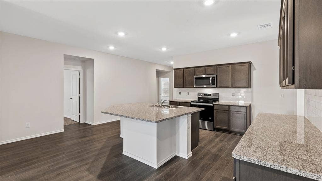 401 Banner Avenue, Royse City, TX 75189 Open-concept kitchen featuring dark wood cabinetry, stainless steel appliances, granite countertops, and a white subway tile backsplash
