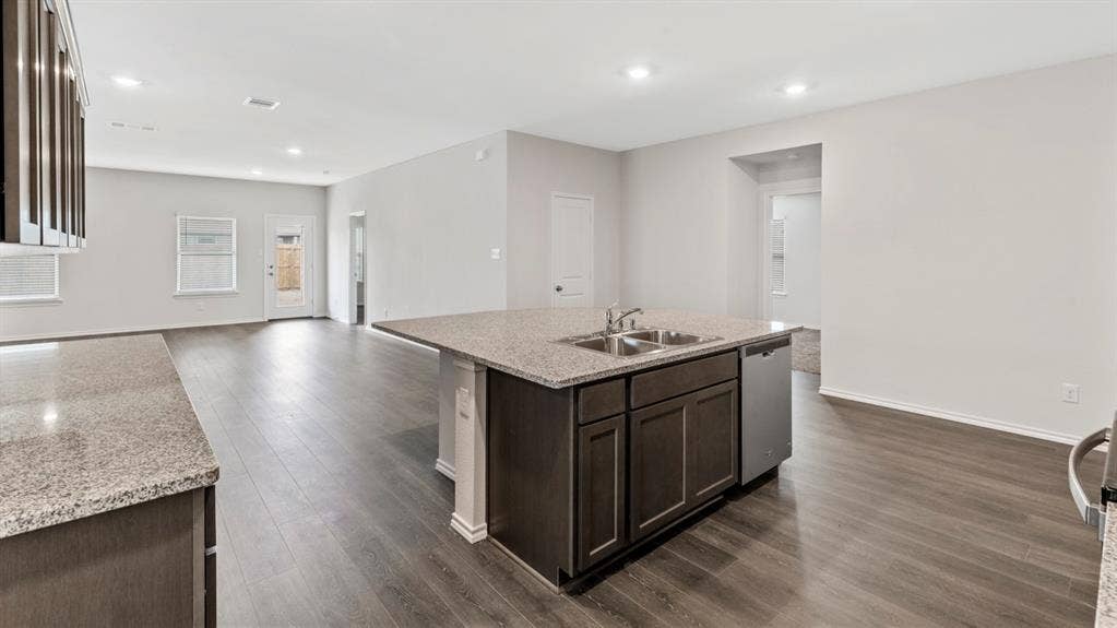 401 Banner Avenue, Royse City, TX 75189 Kitchen island featuring a double-basin sink, stainless steel dishwasher, and stone-finish countertop
