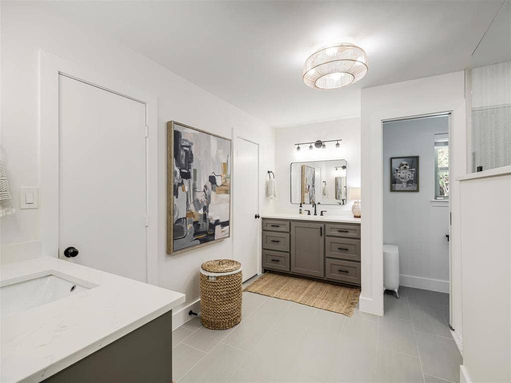 3617 Hackamore Court, Plano, TX 75023 Spa-inspired primary bathroom featuring dual vanity with gray cabinetry, quartz countertops, and polished chrome fixtures