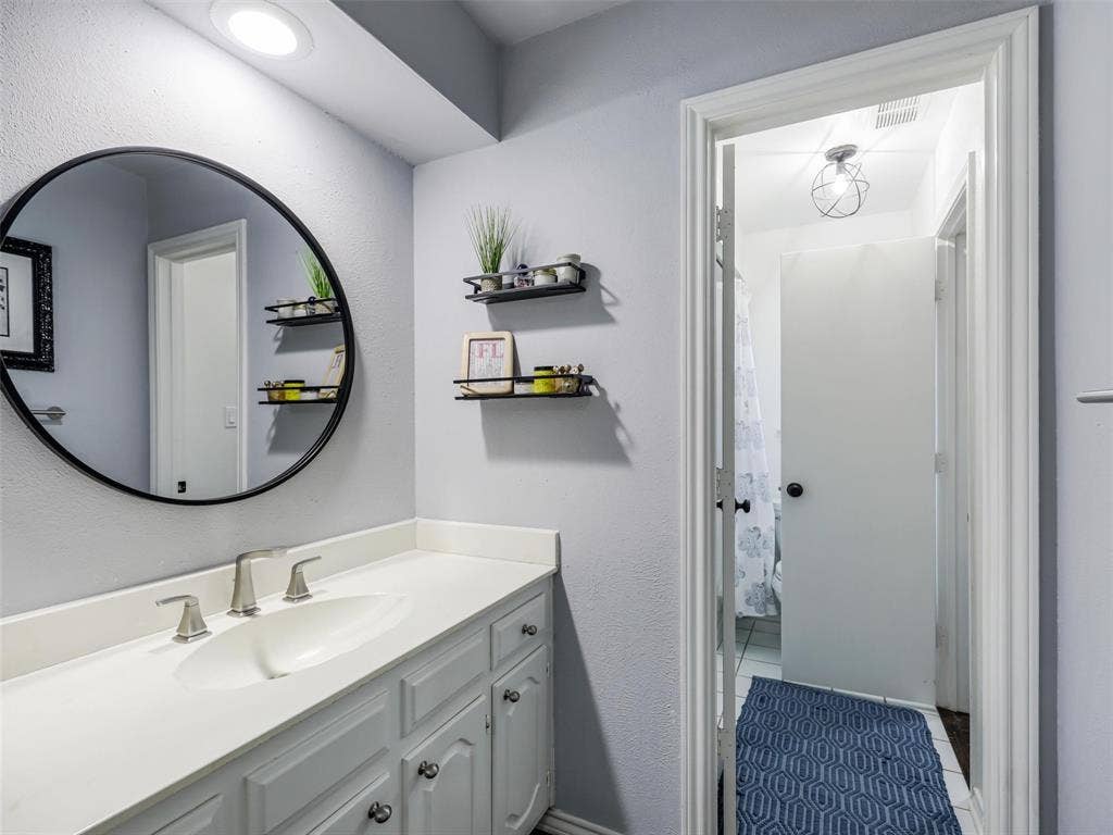 3617 Hackamore Court, Plano, TX 75023 Bathroom vanity featuring a dual-handle faucet and white cabinetry on other side of Jack n Jill bath