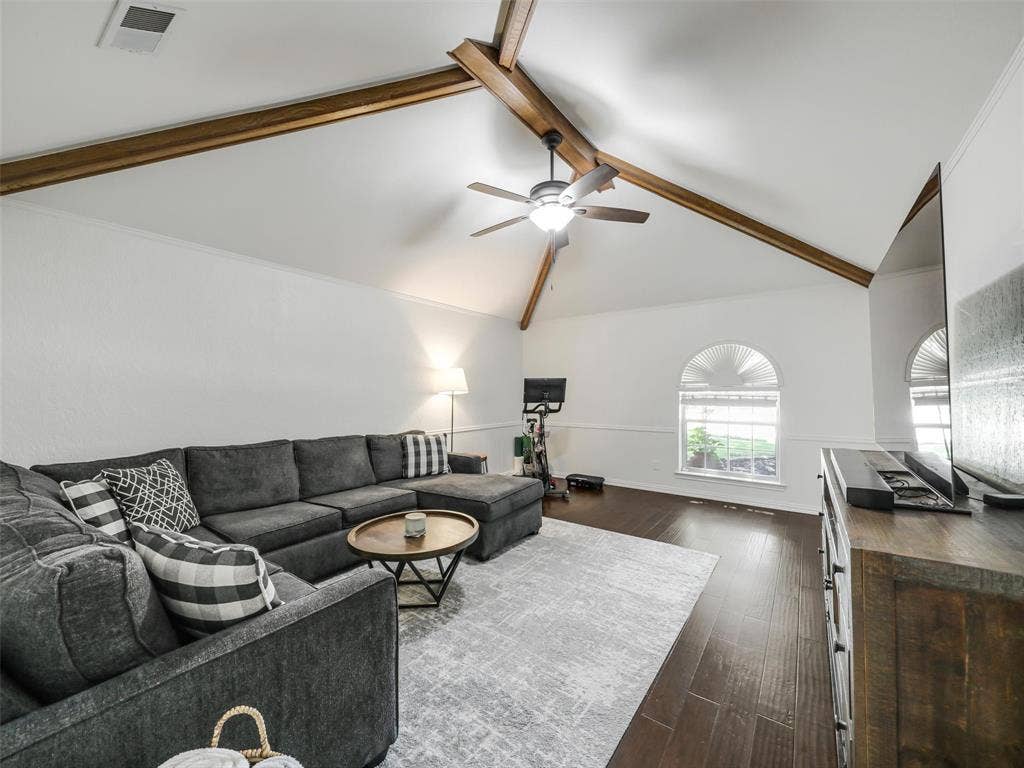 3617 Hackamore Court, Plano, TX 75023 Spacious living area featuring a vaulted ceiling with exposed wood beams, a ceiling fan. Great space for exercise or media!
